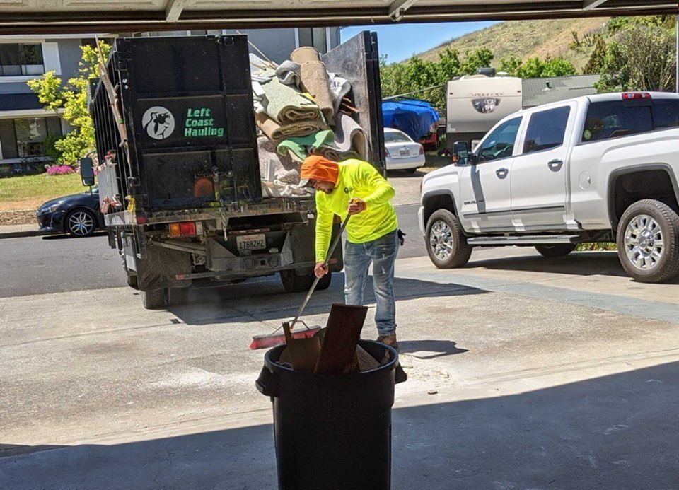 Left Coast Hauling professional sweeping up during junk removal services in the East Bay area