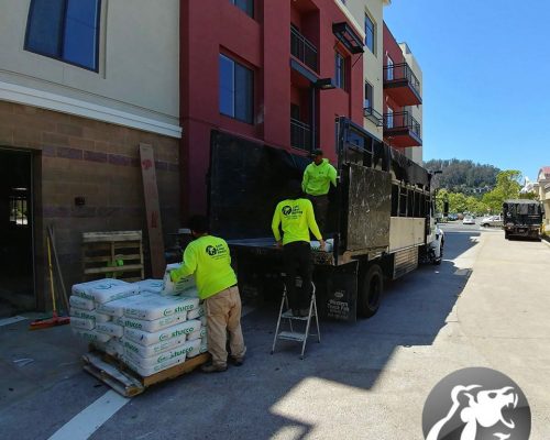Left Coast Hauling crew lifting hauling leftover inventory from a warehouse during curbside pickup services