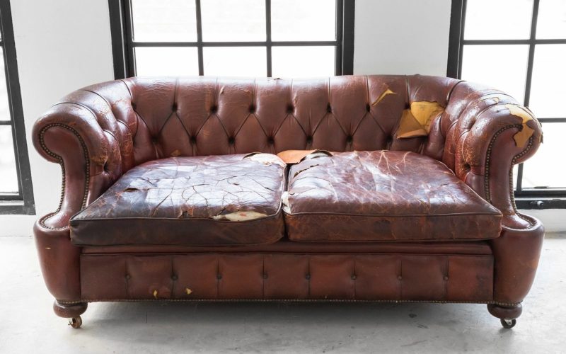 Old leather couch in need of furniture removal services