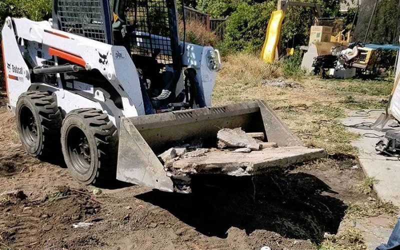 Bobcat excavator performing debris removal services